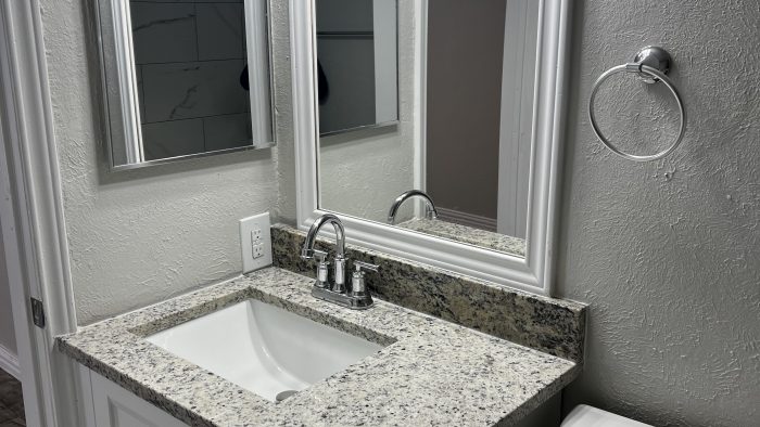 a bathroom with granite counter tops and a sink at The Calypso Court