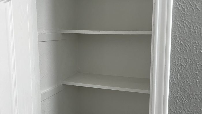 a white closet with shelves and doors at The Calypso Court